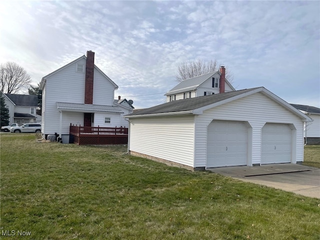 view of home's exterior with a wooden deck, a yard, an outbuilding, and a garage