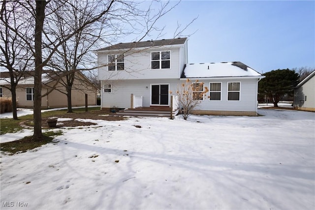 view of snow covered rear of property