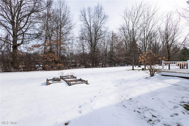 yard covered in snow featuring a wooden deck