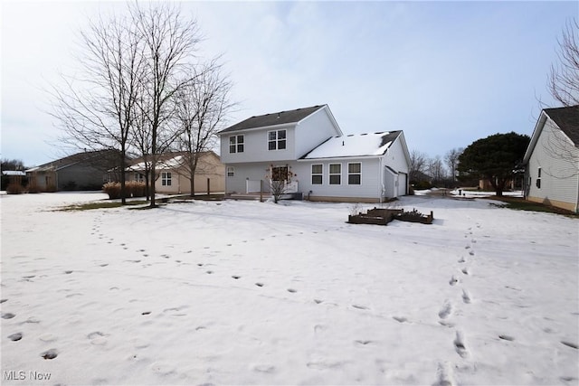 view of snow covered back of property