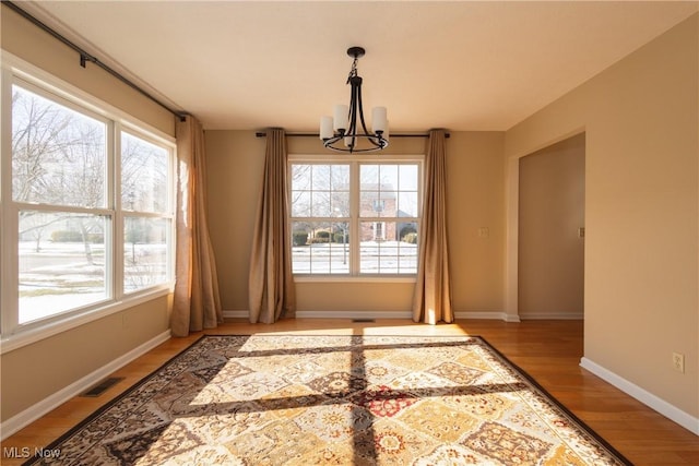 dining room featuring a healthy amount of sunlight, a chandelier, and light hardwood / wood-style floors