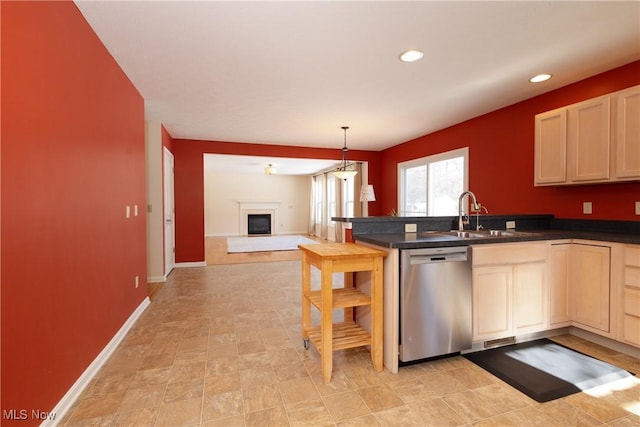 kitchen featuring hanging light fixtures, sink, stainless steel dishwasher, and kitchen peninsula