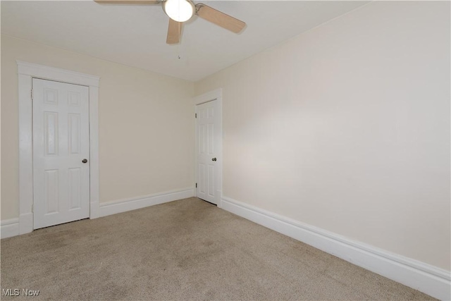 carpeted spare room with ceiling fan