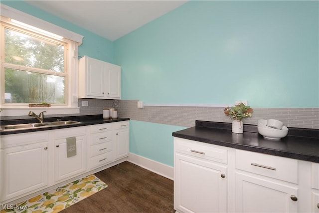 kitchen with dark hardwood / wood-style floors, white cabinetry, sink, and tasteful backsplash