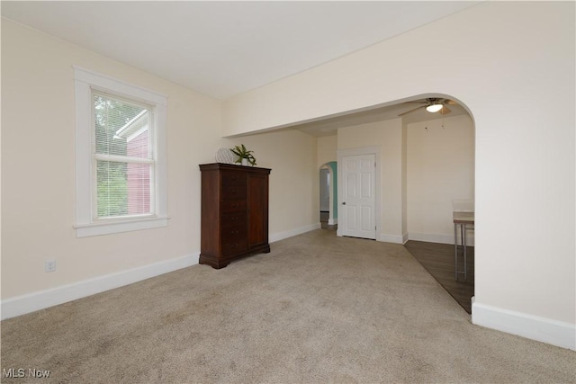 carpeted empty room featuring ceiling fan