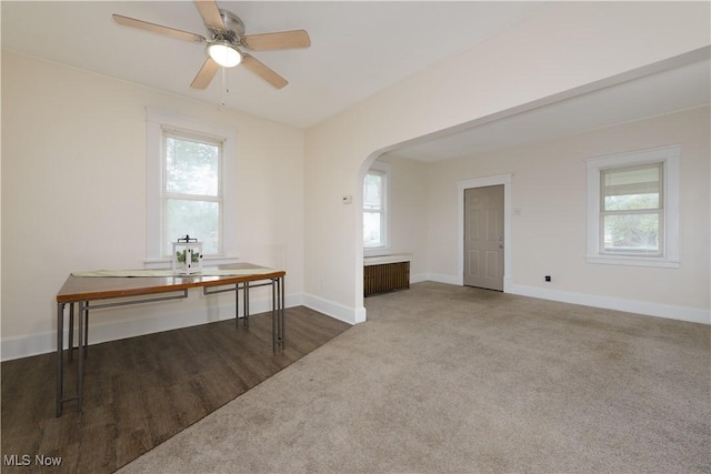 empty room featuring carpet, radiator heating unit, and ceiling fan