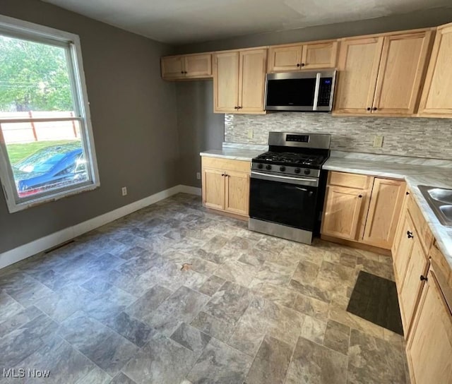 kitchen featuring stainless steel appliances and light brown cabinetry