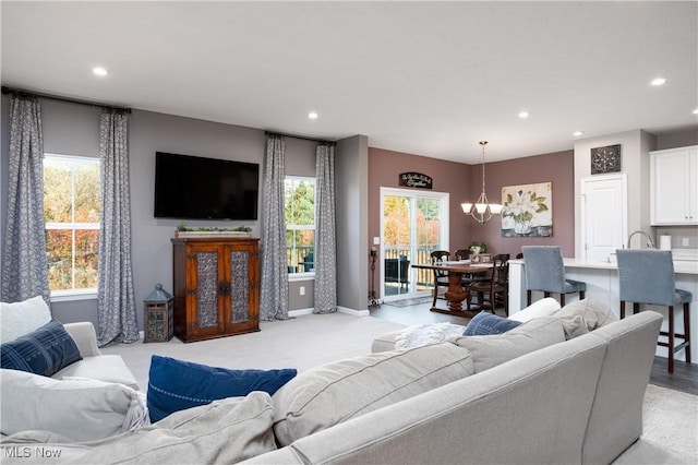 living room with light carpet and an inviting chandelier