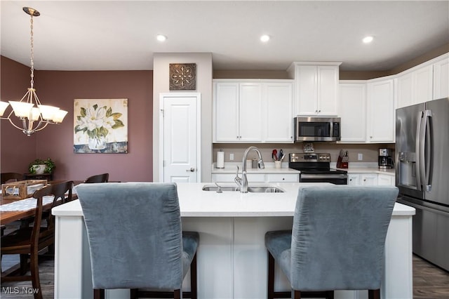 kitchen with pendant lighting, white cabinets, stainless steel appliances, and sink