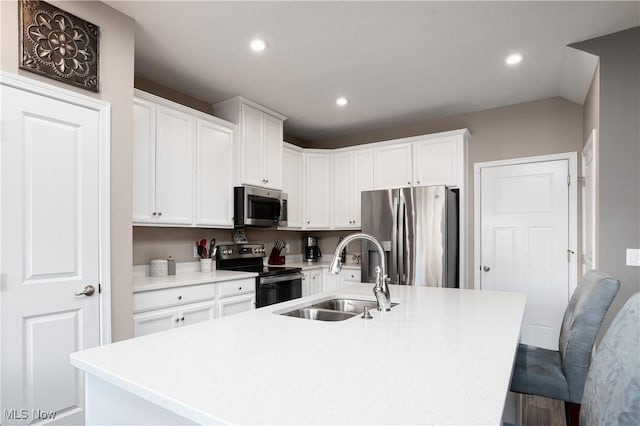 kitchen featuring sink, white cabinetry, stainless steel appliances, and a kitchen island with sink