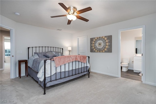 bedroom with connected bathroom, ceiling fan, and light carpet