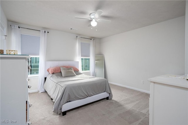 carpeted bedroom with multiple windows and ceiling fan