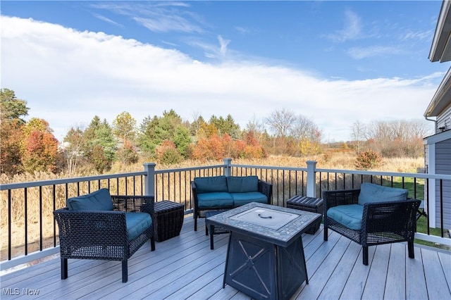 wooden deck with an outdoor living space with a fire pit