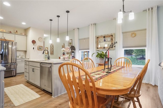 dining space with sink and light hardwood / wood-style flooring