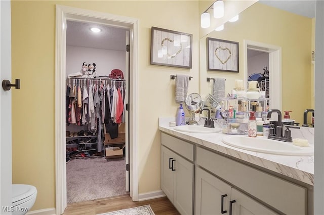 bathroom featuring toilet, vanity, a textured ceiling, and hardwood / wood-style flooring