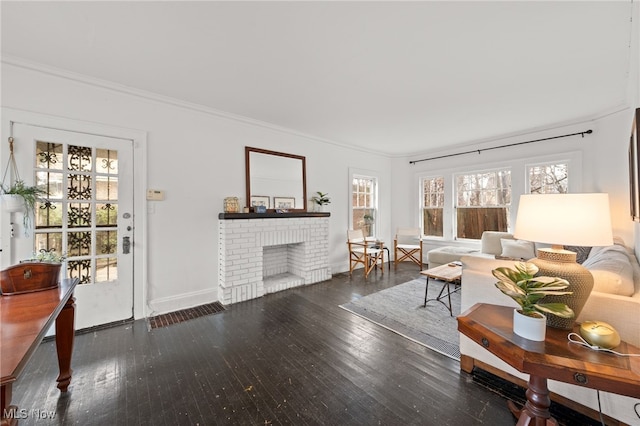 living room with crown molding, a fireplace, and dark wood-type flooring