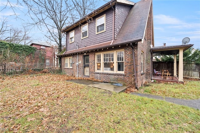 back of property featuring a patio and a lawn