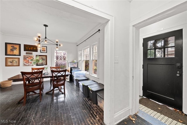 dining room with crown molding, dark wood-type flooring, and a chandelier