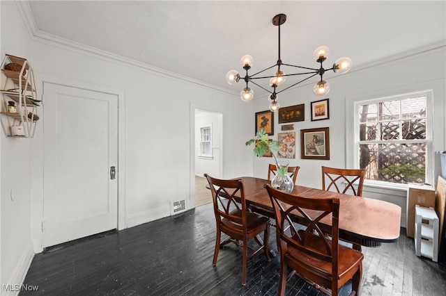 dining room featuring dark hardwood / wood-style floors, ornamental molding, and a chandelier