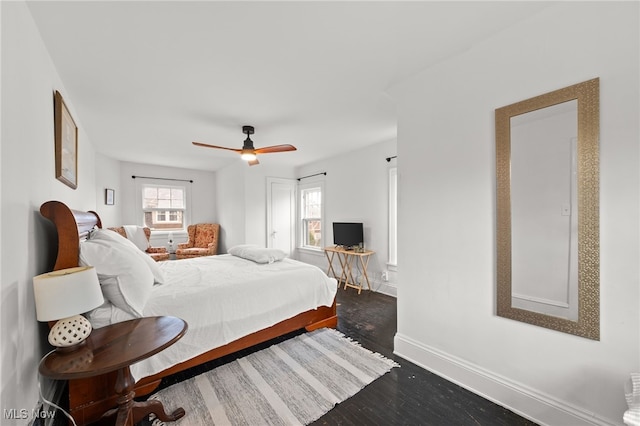 bedroom with ceiling fan and dark hardwood / wood-style floors