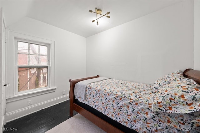 bedroom featuring hardwood / wood-style floors and a notable chandelier