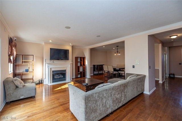 living room with hardwood / wood-style flooring, ornamental molding, and a chandelier