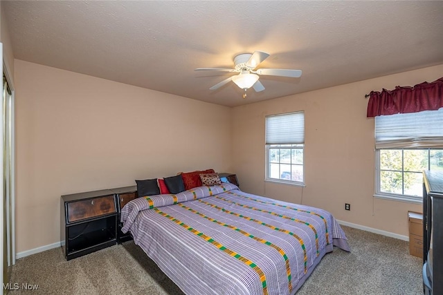 bedroom featuring ceiling fan, light colored carpet, and a textured ceiling