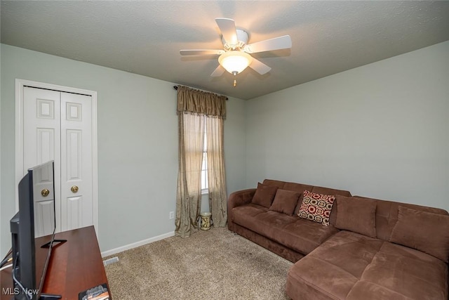 living room with light carpet, a textured ceiling, and ceiling fan