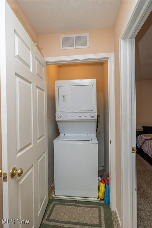 laundry area featuring stacked washer and clothes dryer