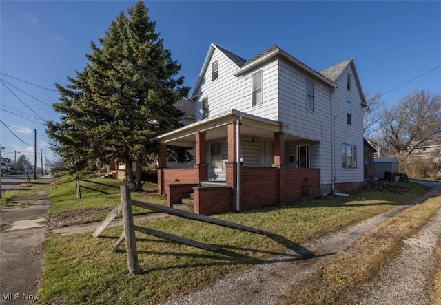 view of side of property featuring a lawn and a porch