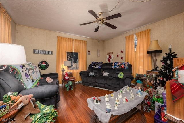 living room with ceiling fan, wood-type flooring, and a textured ceiling