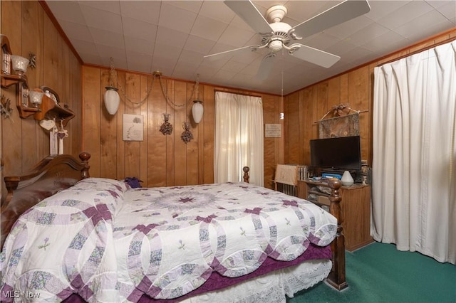 carpeted bedroom with ceiling fan and wood walls