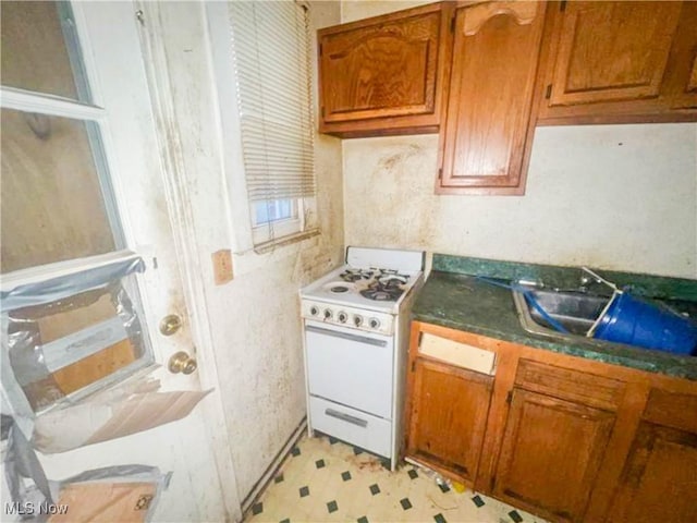 kitchen featuring white gas range and sink