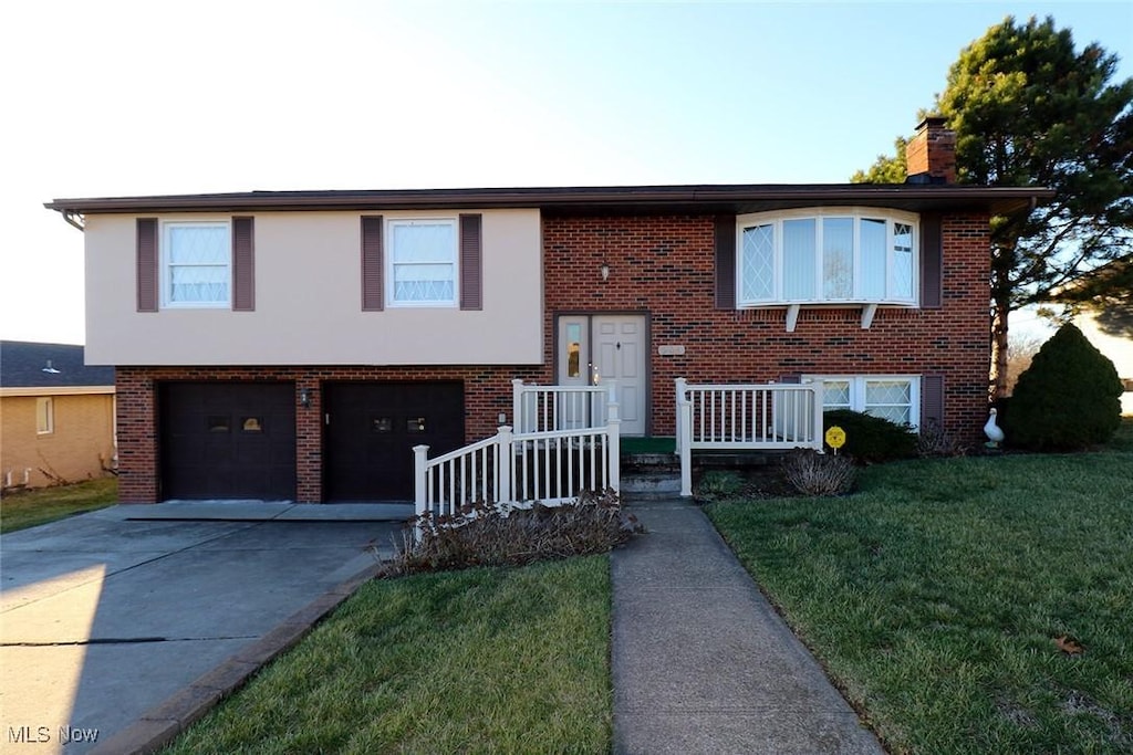 split foyer home with a garage, a front yard, and central AC