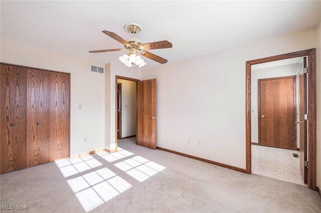 unfurnished bedroom featuring ceiling fan, a closet, and light colored carpet