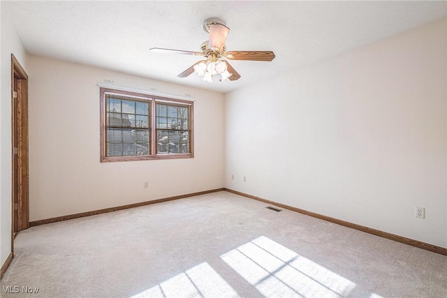 empty room with ceiling fan and light carpet