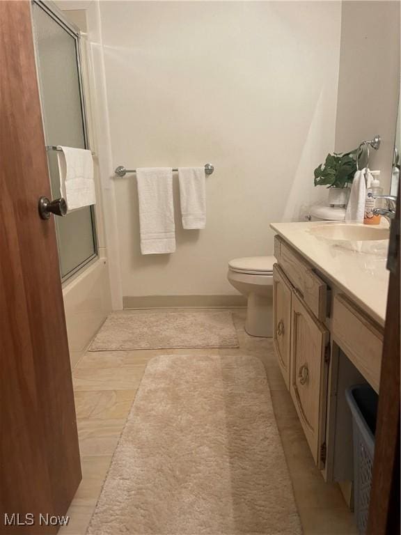 full bathroom featuring shower / bath combination with glass door, vanity, and toilet