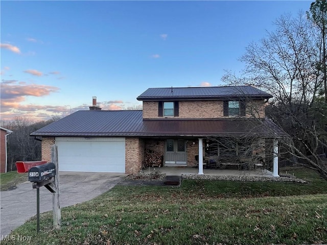 view of front of home with a porch, a garage, and a yard