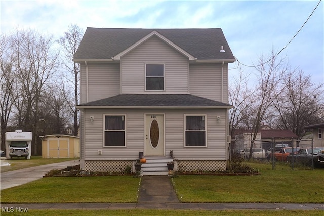 view of front of home featuring a front yard and a storage unit