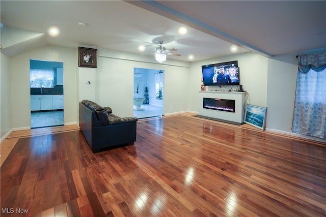 living room with hardwood / wood-style floors, ceiling fan, and sink