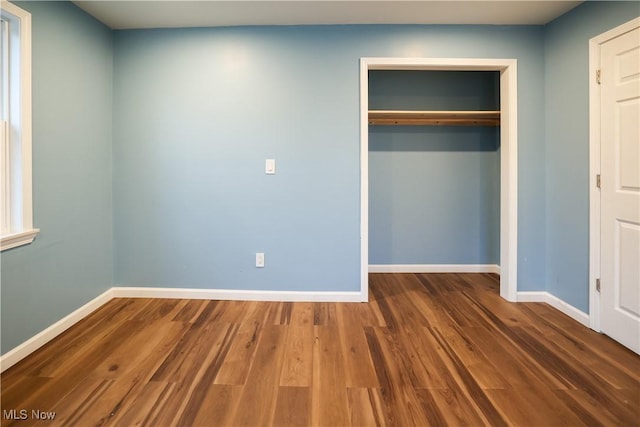 unfurnished bedroom featuring hardwood / wood-style flooring and a closet