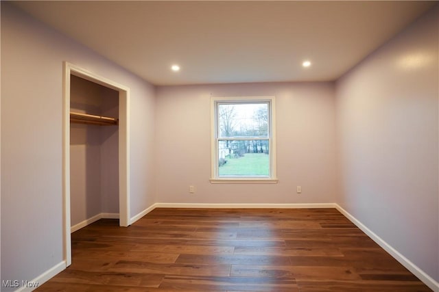 unfurnished bedroom featuring dark hardwood / wood-style floors and a closet