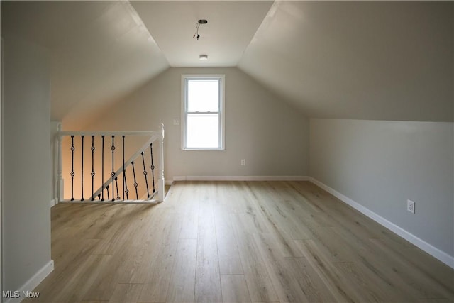 additional living space with lofted ceiling and light wood-type flooring