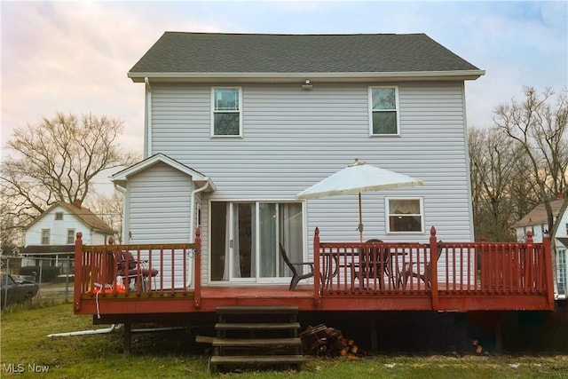 back house at dusk with a wooden deck