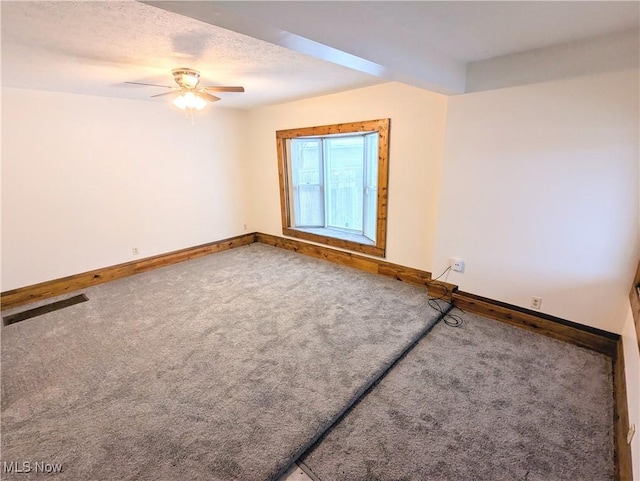 carpeted spare room featuring a textured ceiling and ceiling fan