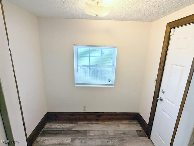 spare room with dark wood-type flooring and a textured ceiling