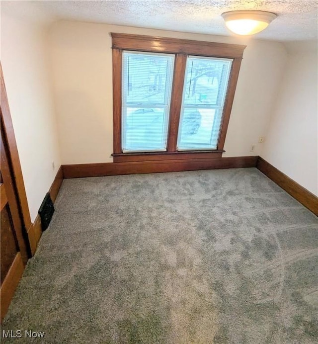 carpeted spare room with a textured ceiling