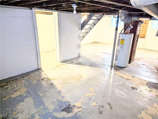 basement featuring a healthy amount of sunlight and electric water heater