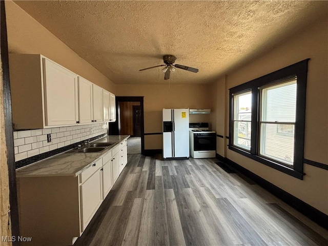 kitchen with decorative backsplash, white appliances, ventilation hood, sink, and white cabinetry