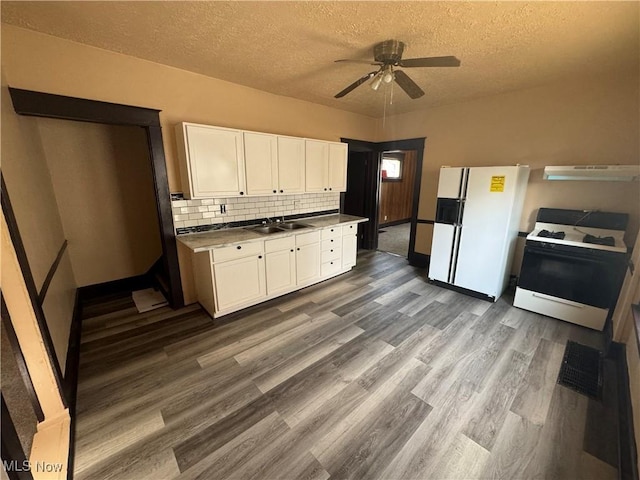 kitchen featuring white cabinetry, range hood, white appliances, and sink